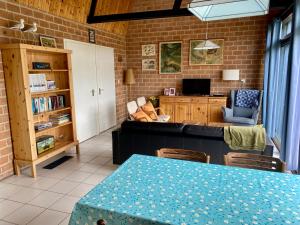 a living room with a table and a couch at Boerenslag 46 in Sint Maartenszee