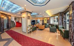 a lobby with chairs and tables and a red rug at Hotel Seren 2 in Istanbul