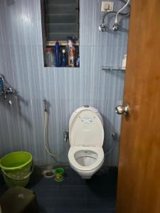 a small bathroom with a toilet and a green bucket at Abode of Peace in Esperance