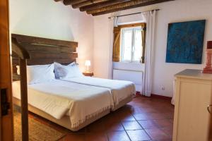 a bedroom with a white bed and a window at Casas de Juromenha in Juromenha +105 photos