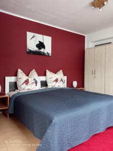 a bedroom with a blue bed and a red wall at Ferienwohnung Kiefernwald in Mechernich