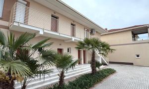 a building with palm trees in front of it at Nanchev Apartments in Gevgelija
