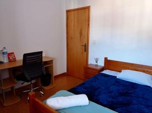 a bedroom with a bed and a desk and a chair at Casa Verde in Braga