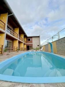 a large blue swimming pool in front of a building at Hotel 5km da Guarda do Embaú in Palhoça