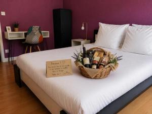 a basket of wine bottles sitting on a bed at Logis Hotel restaurant de la Poste in Pontgibaud