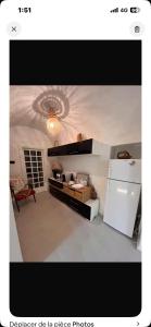 a kitchen with a table and a white refrigerator at دارالقوس in Sfax