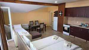 a kitchen and living room with two beds and a table at MARIANA - Luxury stay private guest rooms in Gotse Delchev