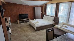 a hotel room with a bed and a television at MARIANA - Luxury stay private guest rooms in Gotse Delchev
