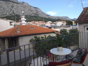 a balcony with a table and chairs and a mountain at Milea in Makarska