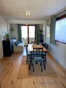 a dining room and living room with a table and chairs at A l'Est d'Eden in Hastière-Lavaux