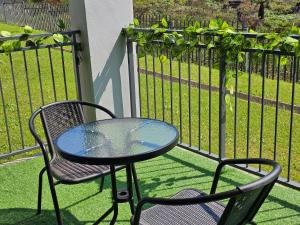 a table and two chairs and a table and a fence at Sky Apartment Mbabane CBD in Mbabane +12 photos