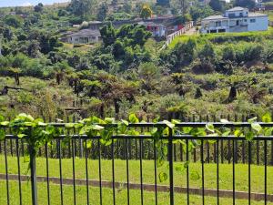 a fence with a view of a hill with houses at Sky Apartment Mbabane CBD in Mbabane