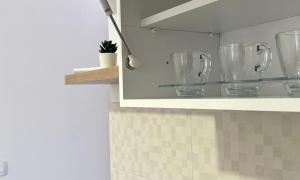 a cupboard with empty glasses on it in a kitchen at Nanchev Apartments in Gevgelija +43 photos