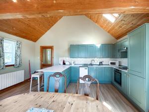 a kitchen with blue cabinets and a wooden table at Rosscot in Ankerville