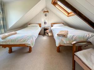 a attic bedroom with two beds and a window at Rosscot in Ankerville