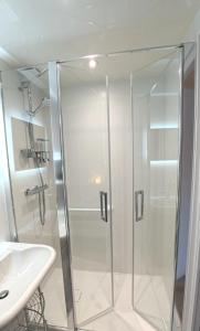 a shower with a glass door next to a sink at Le casse noisettes in Gourin +26 photos