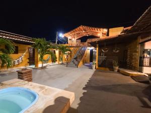 a outdoor swimming pool with a bath tub in front of a building at Pousada pôr do sol in Riachuelo