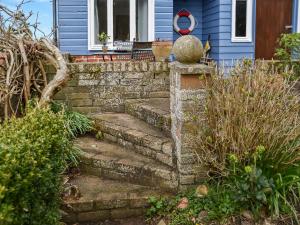 a set of stone stairs in front of a blue house at Riverside Retreat in Beccles