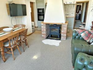 a living room with a table and a fireplace at Meadow View Broadlea in Stokeham