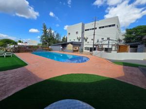 a swimming pool in front of a building at Hotel Izzy Stay in Maputo