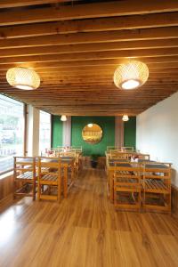a restaurant with wooden tables and chairs and green walls at Drizzle Drop Inn in Ooty