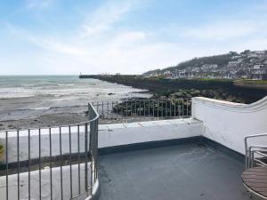 a view of a beach with a fence and the ocean at Hen Joppa in Newlyn