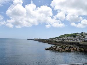 a large body of water with a pier and buildings at Hen Joppa in Newlyn