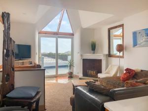 a living room with a couch and a large window at Hen Joppa in Newlyn