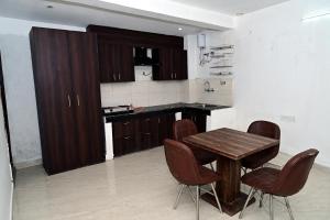 a kitchen with a wooden table and chairs at Shanti Residency Ramgarh in Rāmgarh +9 photos