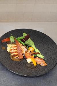 a plate of food with meat and vegetables on it at Hotel ALMA in Wassenberg