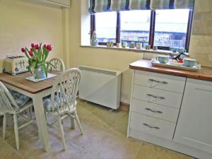 a kitchen with a table and chairs and a sink at Rundales Cottage in Appleby +3 photos