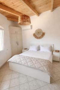 a bedroom with a white bed and a wooden ceiling at Sesi Luxury Suites Seaside & Private Pool in Marathon +17 photos