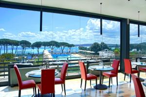 a restaurant with tables and chairs and a view of the water at HA Hotel in Bracciano