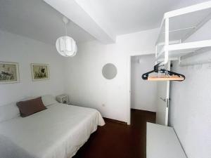 a white bedroom with a bed and a white wall at La Mata relax in La Mata