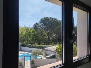 a window with a view of a swimming pool at Chambre 2 pers SPA Piscine in Grospierres