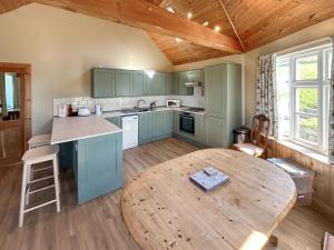 a kitchen with a wooden table and a wooden ceiling at Rosscot in Ankerville +11 photos