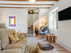 a living room with a couch and a tv at Dyffryn Glanffrwd Mill in Cellan