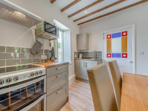 a kitchen with a stove and a wooden table at Dyffryn Glanffrwd Mill in Cellan +13 photos