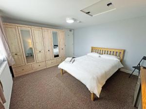 a bedroom with a large bed and wooden cabinets at Riverside Cottage in Spalding