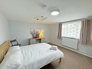 a bedroom with a white bed and a window at Riverside Cottage in Spalding