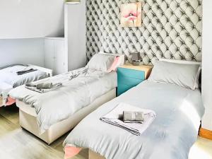 a room with two beds and a wall at Grantham House in Grantham +4 photos