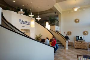
people are standing in a lobby of a building at Escapes! To The Shores Orange Beach, A Ramada by Wyndham in Orange Beach
