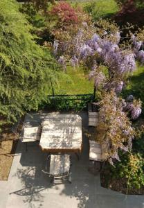 ein Picknicktisch und eine Bank in einem Garten mit Blumen in der Unterkunft 3Aceri in Arcore