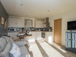 a kitchen with a couch and a table in it at Cow Pasture Cottage in Hallington