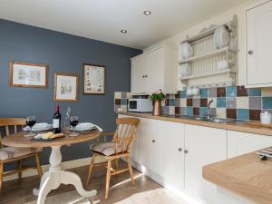 a kitchen with a table with wine glasses on it at Cow Pasture Cottage in Hallington