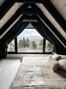a bedroom with a bed and a large window at helloduna in Dunabogdány