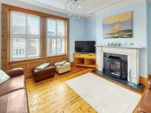 a living room with a fireplace and a television at Longsands Retreat in Tynemouth