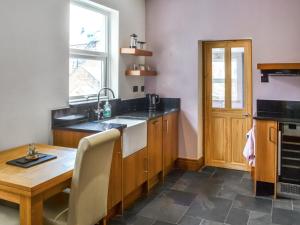 a kitchen with a wooden table and a sink at Longsands Retreat in Tynemouth +13 photos