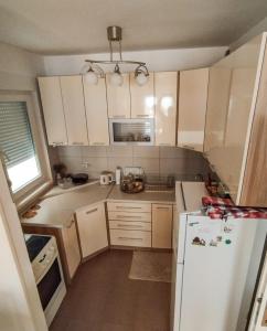 a small kitchen with white cabinets and a white refrigerator at Studio Centar in Trebinje