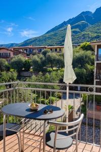 a patio with a table and chairs and an umbrella at Hotel Luisa in Brenzone sul Garda